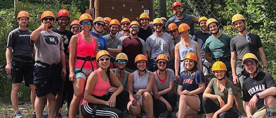 large group of people wearing safety helmets on a retreat
