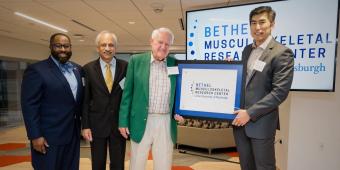 Image of three men presenting a financial gift to the Bethel Musculoskeletal Research Center