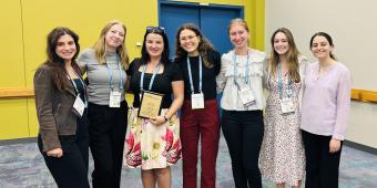 an image of Dr. Corina Bondi and associates receiving the Faculty for Undergraduate Neuroscience Mentor award