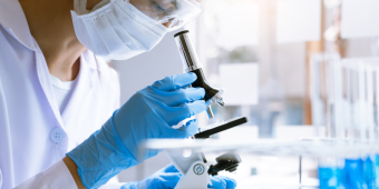 scientist looking through microscopt