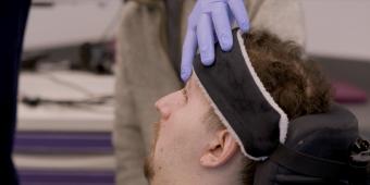 hand wearing a rubber glove examines the head of a male patient